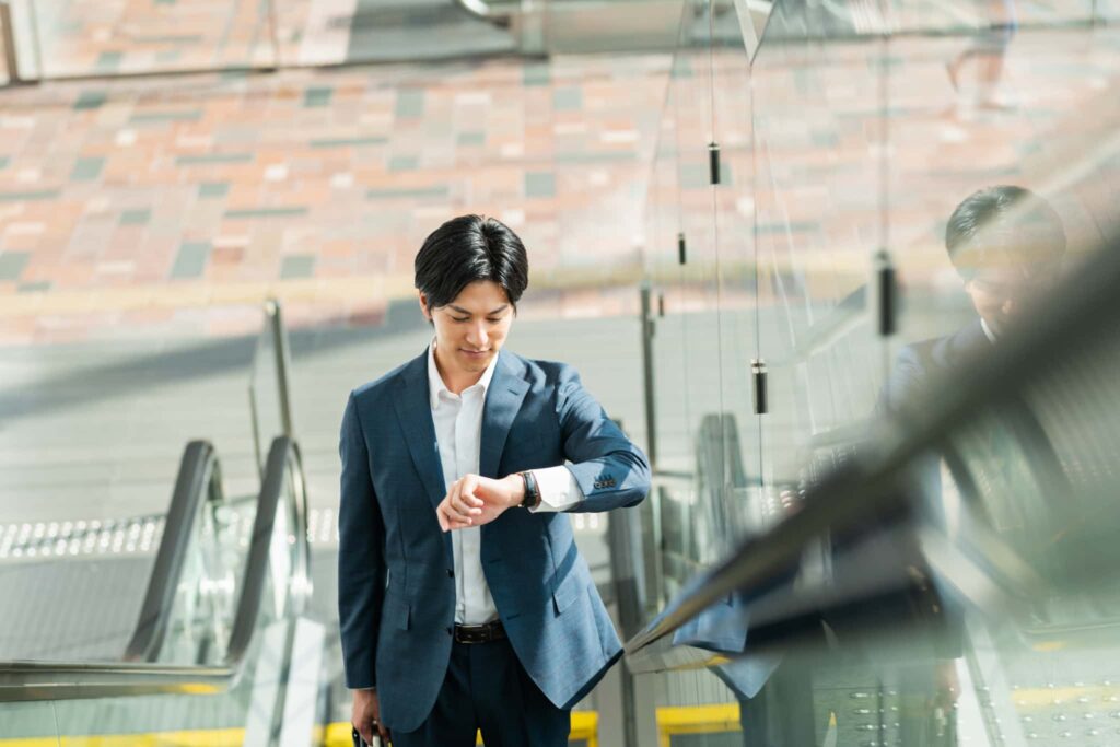 腕時計で時間を確認する男性